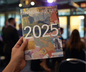 Hand holding a modern, visually engaging annual report for 2025, titled "Annual Report" with a creative mountain and map design, at a public event, symbolizing transparent public sector communication in India. Modern Annual Report Design 2025 for Government Agencies in India
