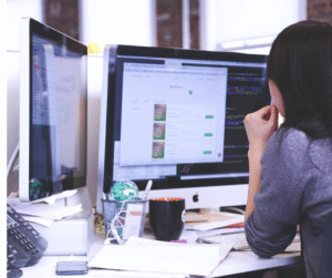Woman analyzing website content strategy on dual monitors for SEO growth